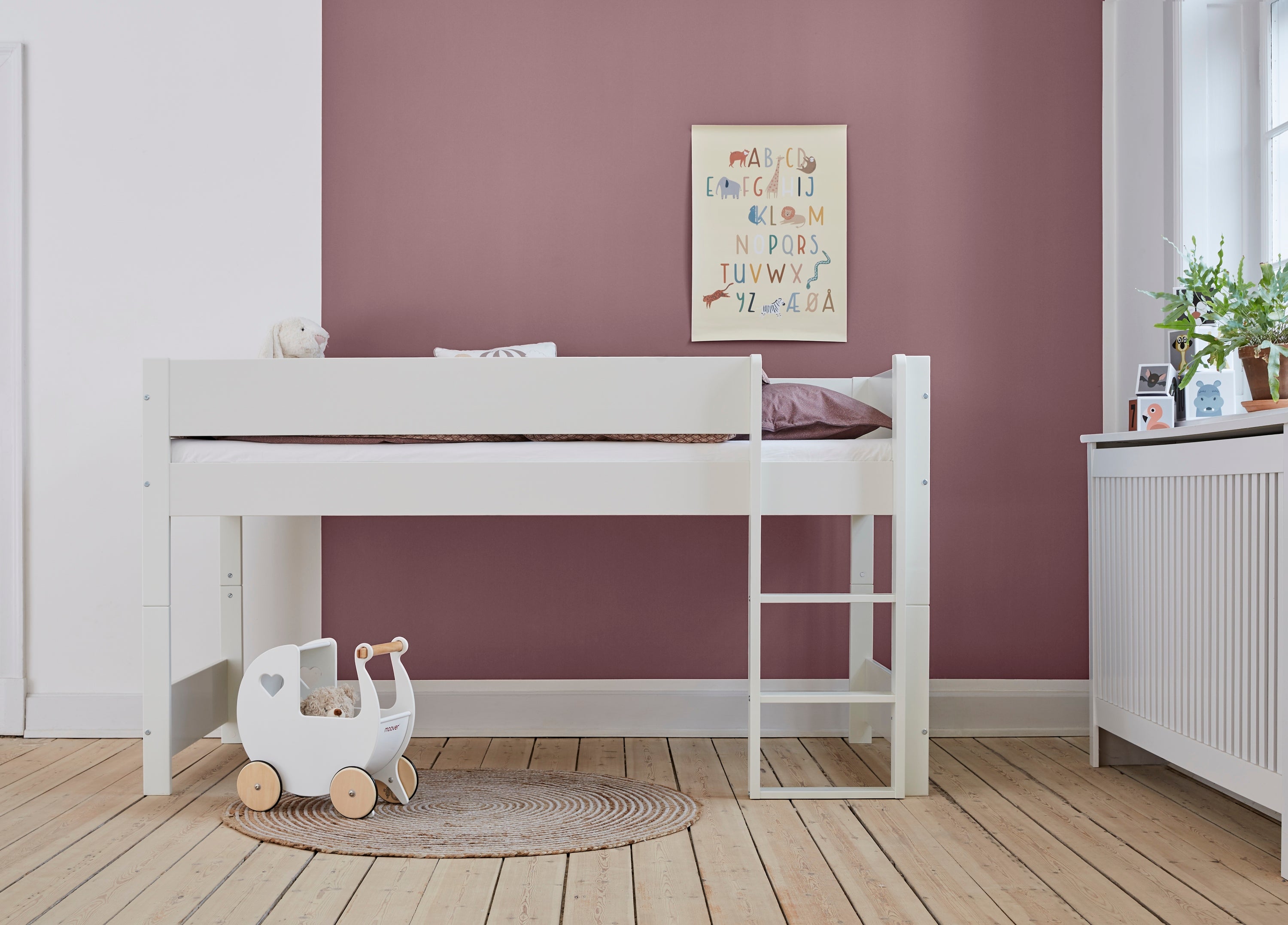 Hvid Huxie halvhøj seng med stige, legetøj og en alfabetplakat i et børneværelse