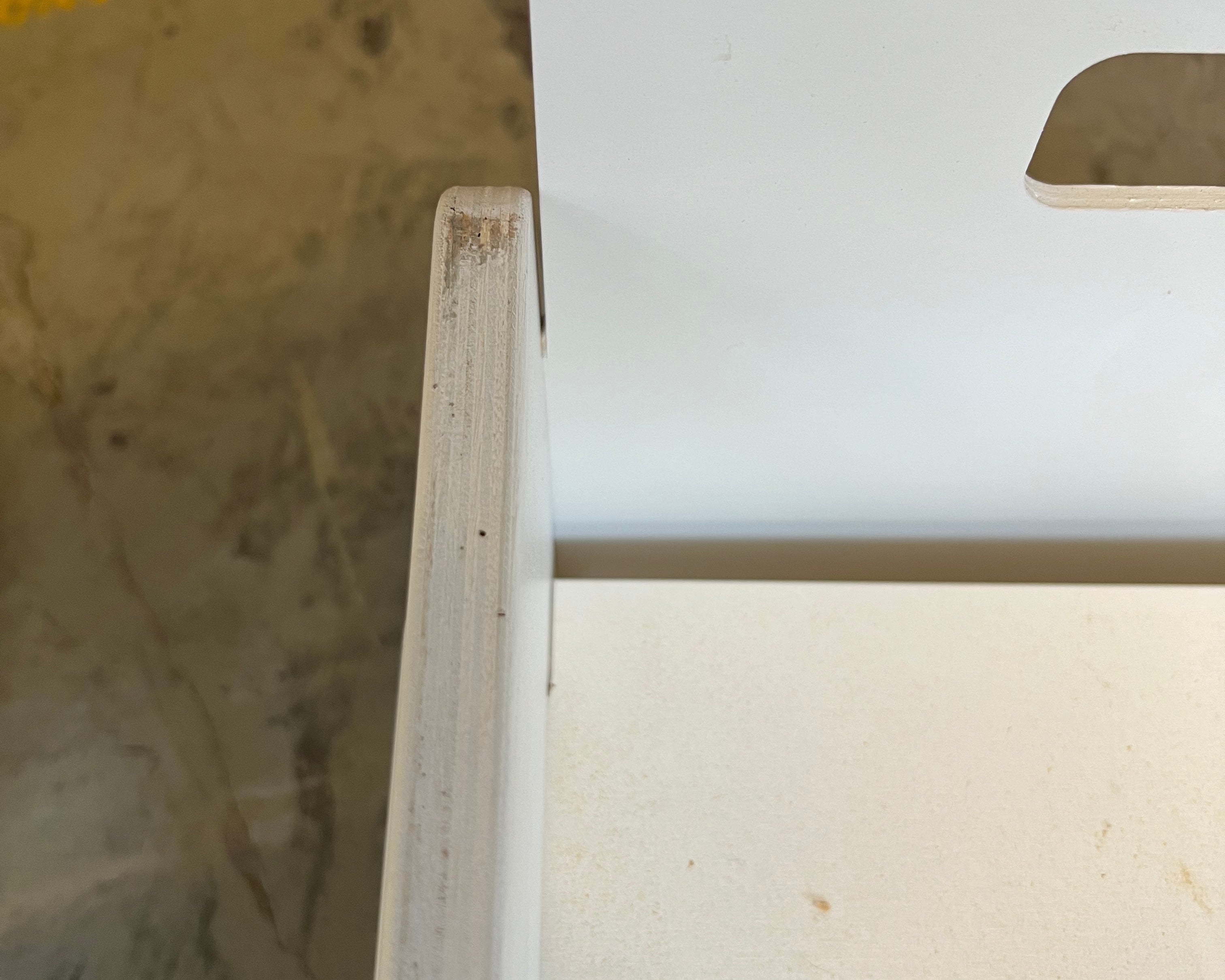 Detaljebillede af en Snow white Flip-vip bænk med ridser på siden, hvilket indikerer preloved stand