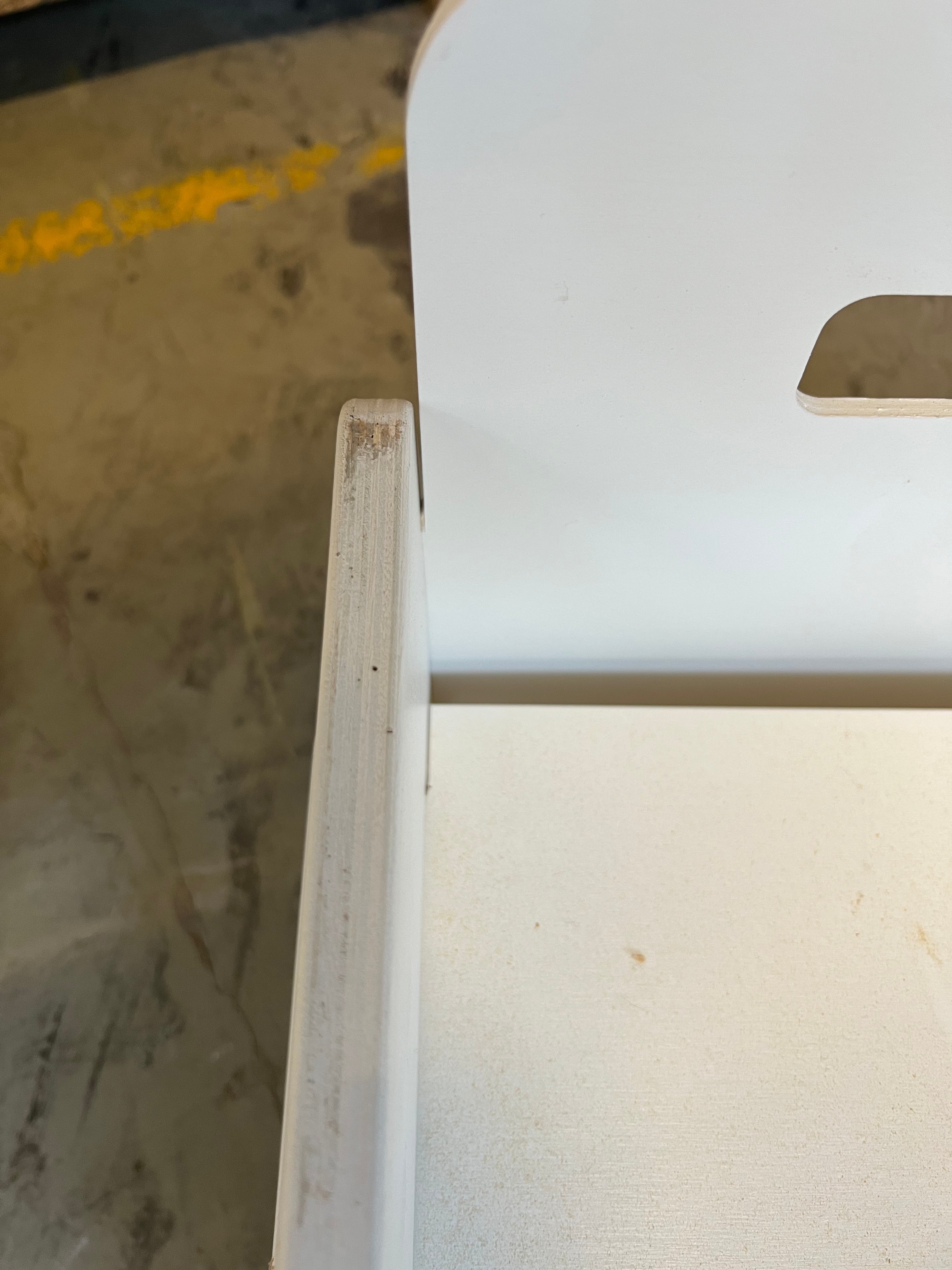 Detaljebillede af en Snow white Flip-vip bænk med ridser på siden, hvilket indikerer preloved stand
