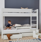 Hvid køjeseng med et barn der læser i den nederste køje, med sengehest og skuffer